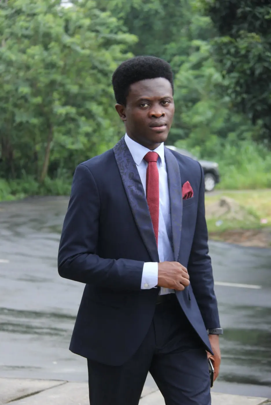 Taiwo Peace Oyeniyi in a navy suit and red tie